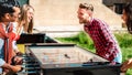 Multicultural friends play kicker table foosball at open space bar -Friendship life style concept with happy millennials Royalty Free Stock Photo