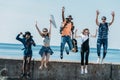 multicultural group of young friends jumping of