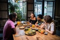 A multicultural group of young people in a cafe, eating asian fo Royalty Free Stock Photo