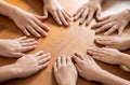 Multicultural hands man woman children in circle on brown wooden background.