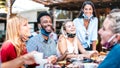 Multicultural people drinking cappuccino at coffee bar - Friends having fun together at cafeteria with face masks Royalty Free Stock Photo