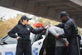 Multicultural police officers arresting hooded offender