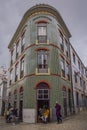 Multicultural street corner scene in Lisbon with an azulejo tiled building in background in Lisbon, Portugal