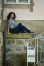 Multicultural woman sitting near the wall of the house in Porto Royalty Free Stock Photo