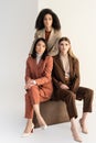 Multicultural women in stylish suits looking