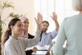 Multicultural employees raise hand vote unanimously at group meeting