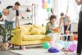 multicultural young friends decorating living room with balloons and party