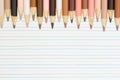 Multiculture skin tone color pencils background on lined paper Royalty Free Stock Photo