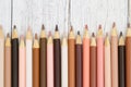 Multiculture skin tone color pencils background on weathered wood Royalty Free Stock Photo