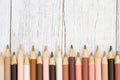 Multiculture skin tone color pencils background on weathered wood Royalty Free Stock Photo