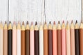 Multiculture skin tone color pencils background on weathered wood Royalty Free Stock Photo