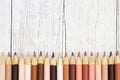 Multiculture skin tone color pencils background on weathered wood Royalty Free Stock Photo