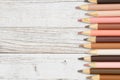 Multiculture skin tone color pencils crayons background on weathered wood Royalty Free Stock Photo