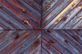 Multidirectional painted wooden plank on the facade of an old country house in Siberia.
