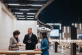 A trio of people engage in a focused business discussion over documents, with the vibrant city lights providing an Royalty Free Stock Photo