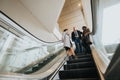 Multiethnic business team having discussion on escalator in modern office building. Royalty Free Stock Photo