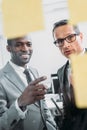 multiethnic businessmen looking at sticky notes on meeting Royalty Free Stock Photo