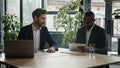 Multiethnic Caucasian and African American business people diverse multiracial men two male partners sitting at office Royalty Free Stock Photo