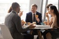 Multiethnic colleagues talk enjoying pizza and coffee at lunch break Royalty Free Stock Photo