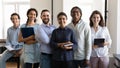 Multiethnic confident group of happy employees holding notebooks