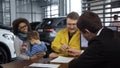 Multiethnic couple buying car in salon Royalty Free Stock Photo