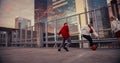 Multiethnic Diverse Group of Friends Playing Soccer on Rooftop Urban City Spot at Sunset. Stylish Royalty Free Stock Photo