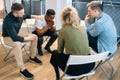 Multiethnic diverse people supporting depressed African American young male during group therapy session. Royalty Free Stock Photo