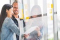 Multiethnic diverse group meeting write project plan on transparent glass board. Small business startup or teamwork concept Royalty Free Stock Photo