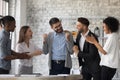 Multiethnic employees congratulate male colleague with promotion Royalty Free Stock Photo