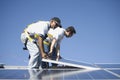 Multiethnic Engineers Placing Solar Panel Against Sky Royalty Free Stock Photo