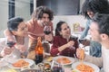 Multiethnic friends eating pasta and drinking wine at home Royalty Free Stock Photo