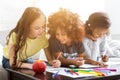 Multiethnic girls drawing at table with colorful pencils
