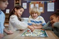 Multiethnic group of little children playing board game together Royalty Free Stock Photo