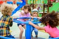 multiethnic group of little kids riding on carousel