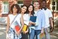 Multiethnic group of students standing near college building, posing at camera Royalty Free Stock Photo