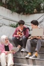 A multiethnic group of university students is studying together while sitting on steps near the campus and communicating Royalty Free Stock Photo