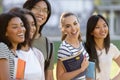 Multiethnic group of young happy students standing outdoors.