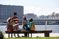 Multiethnic group of young people as college students relaxing in riverside park Royalty Free Stock Photo