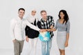 Multiethnic group of young people holding hands on the Earth globe and standing isolated on white background. Earth day Royalty Free Stock Photo