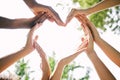 Multiethnic hands making a heart shape outside in nature. Closeup of a group of people making a heart as a concept of Royalty Free Stock Photo