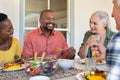 Multiethnic mature men and women eating lunch