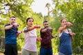 Multiethnic mature people exercising in park with dumbbells at park Royalty Free Stock Photo