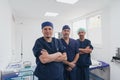 Multiethnic orthopedic doctor in front of his medical team looking at camera wearing face mask Royalty Free Stock Photo