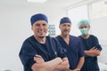 Multiethnic orthopedic doctor in front of his medical team looking at camera wearing face mask Royalty Free Stock Photo