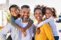 Multiethnic parents giving children piggyback ride Royalty Free Stock Photo