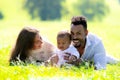 Multiethnic parents and mixed race baby in park. Multiethnic family outdoor portrait. Biracial baby child on yard Royalty Free Stock Photo
