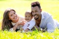 Multiethnic parents and mixed race baby in park. Multiracial family outdoor portrait. Biracial baby child on yard Royalty Free Stock Photo