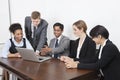 Multiethnic professionals using laptop at conference room Royalty Free Stock Photo