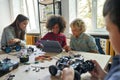 Multiethnic school kids students making robotic cars using tablet computer. Royalty Free Stock Photo