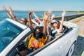 multiethnic smiling friends riding car while